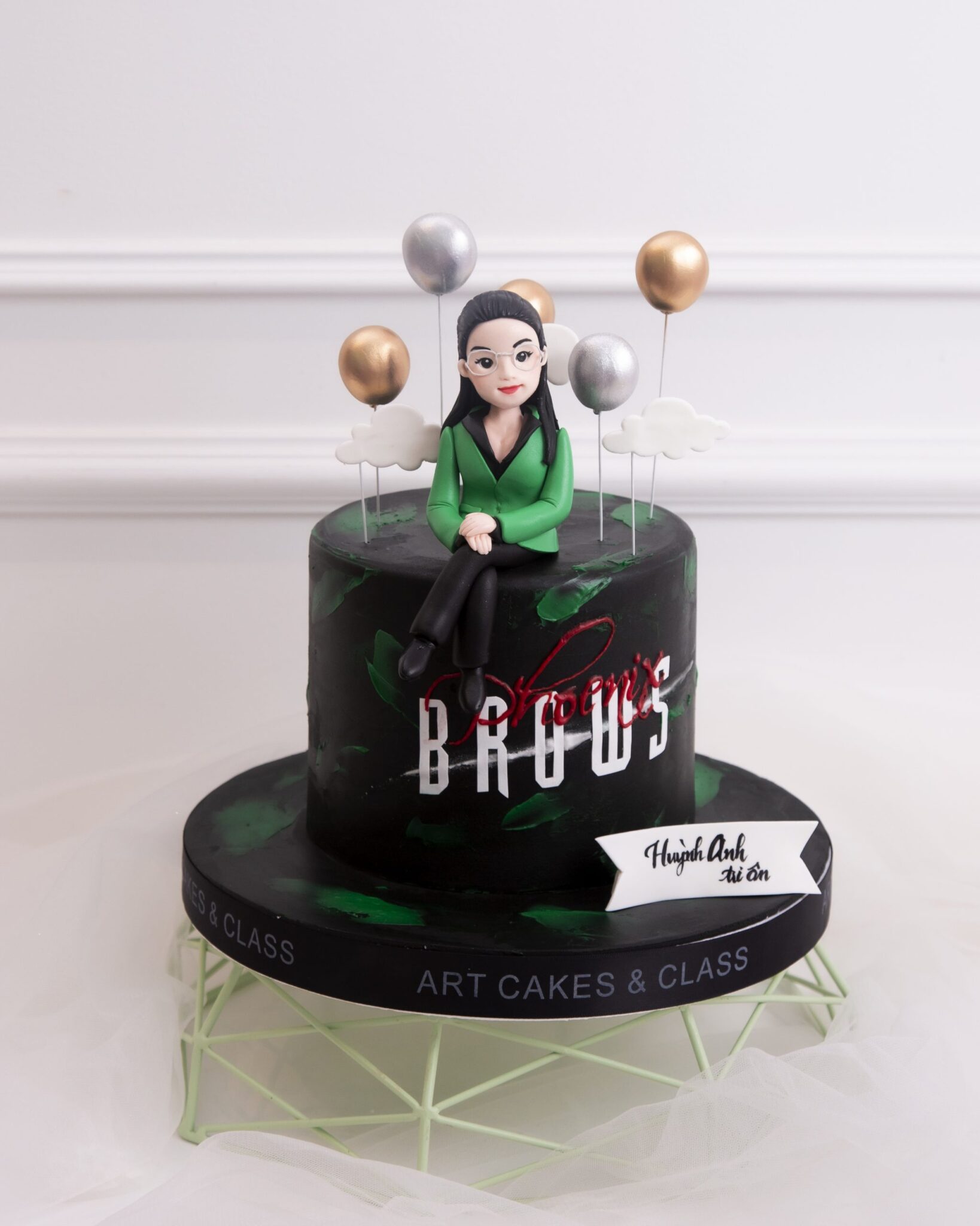 Bánh sinh nhật hiện đại tạo hình chị Quỳnh Trân xinh đẹp được lấy từ ý tưởng bởi những người yêu mến chị phối cùng sắc đen và xanh lá vô cùng bắt mắt.
