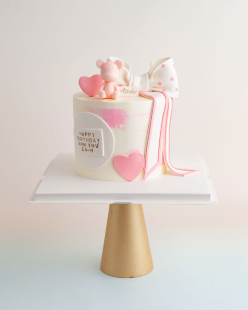 Bánh sinh nhật trang trí đơn giản nơ và gấu tặng sinh nhật Anh Thư với sắc màu trắng hồng vô cùng tinh tế.
